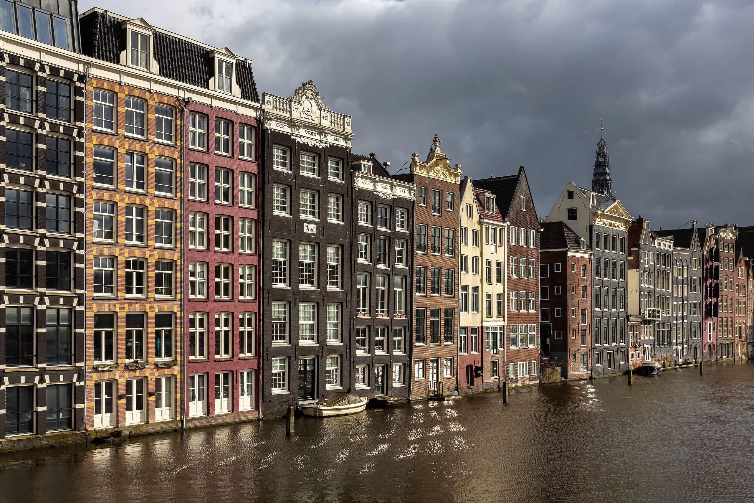 Colorful_canal_houses_at_golden_hour_in_Damrak_avenue_Amsterdam_the_Netherlands